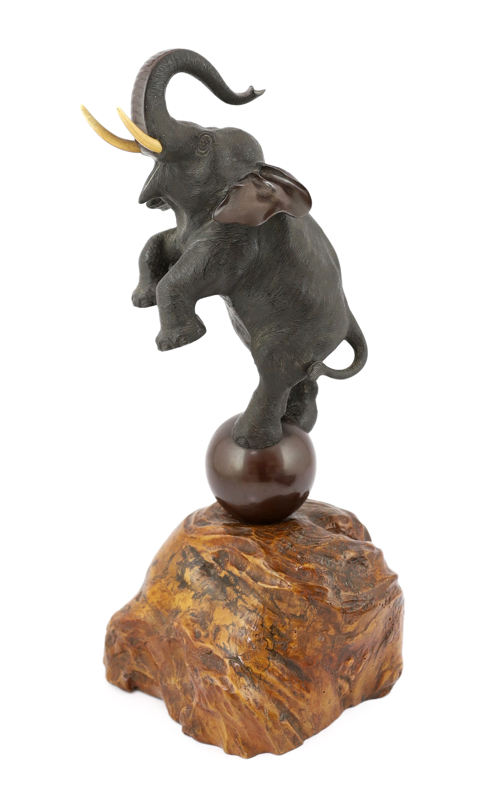 A Japanese bronze model of a rearing elephant standing on a ball, Meiji period